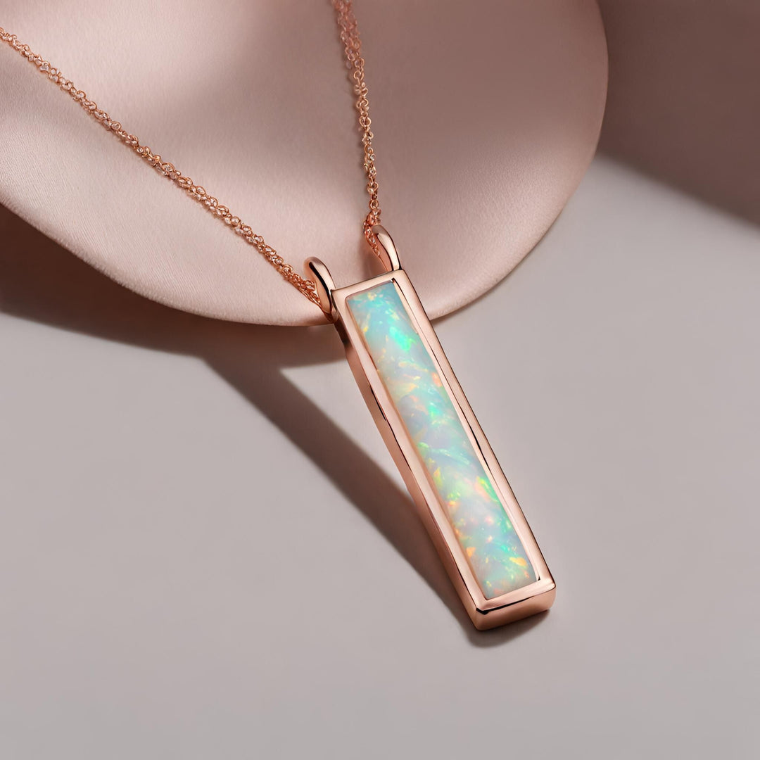 A long rectangular Opal pendant in a modern bezel setting in 14K Rose Gold from Rare Earth Jewelry.