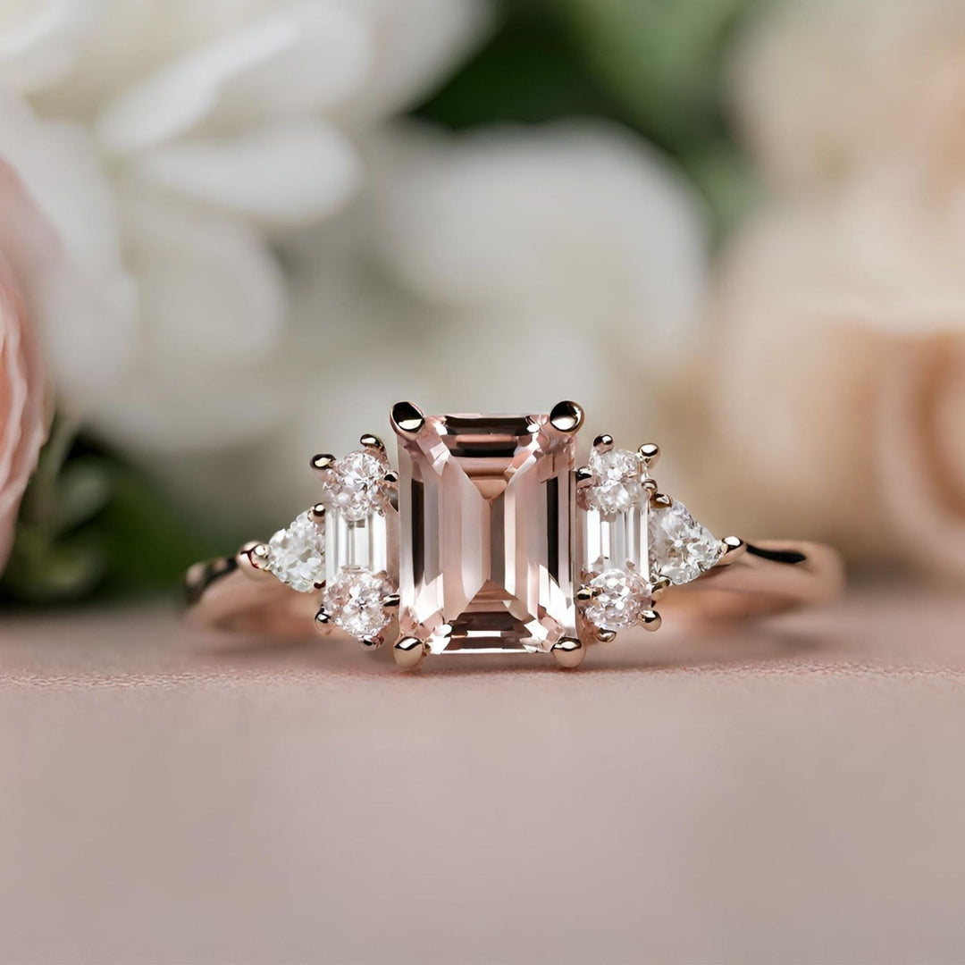 An emerald cut pink Morganite engagement ring with round diamonds, baguettes and trillions from Rare Earth Jewelry.