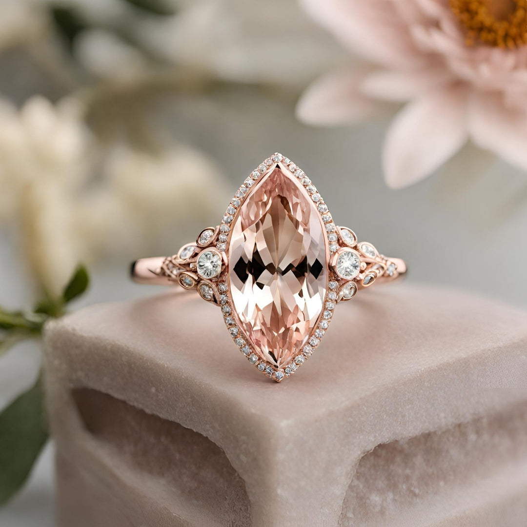 Morganite marquise cut engagement ring bezel set with diamond halo in rose gold from Rare Earth Jewelry.