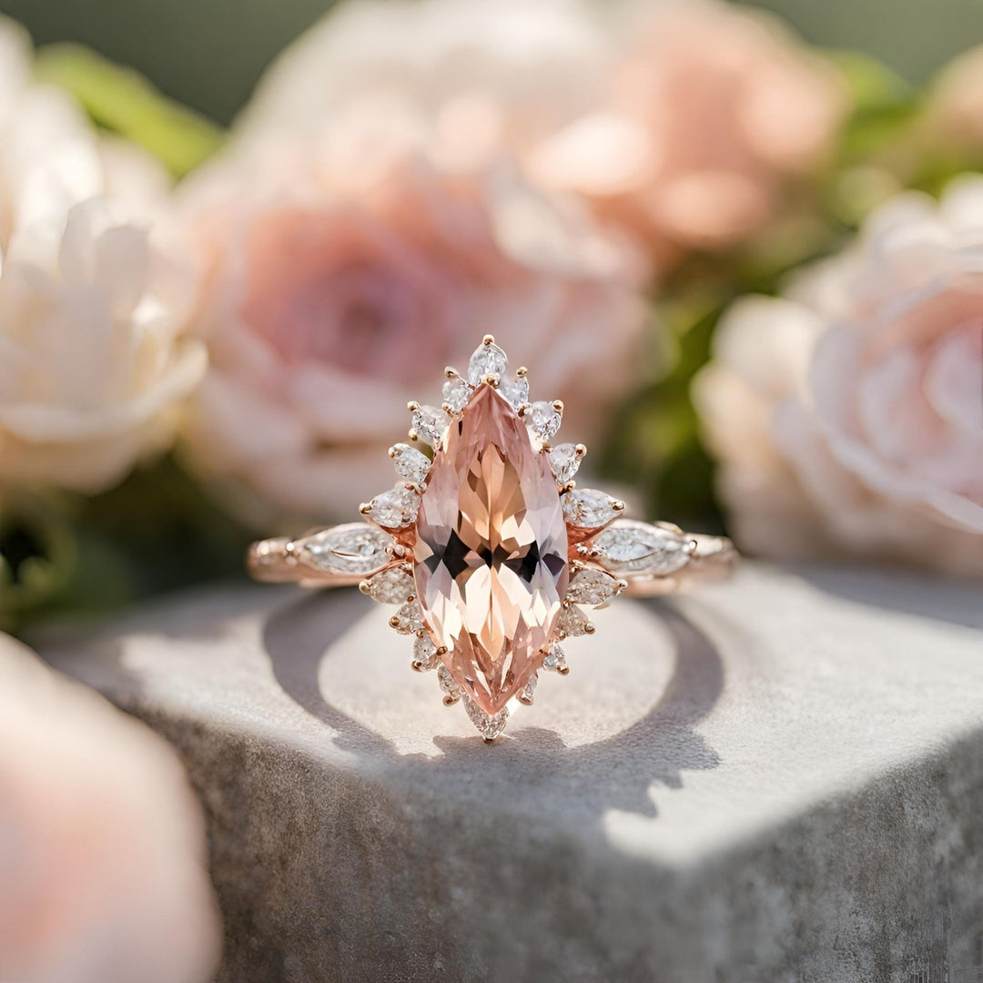 A stunning marquise cut Morganite engagement ring with a feminine cluster style halo in rose gold from Rare Earth Jewelry.