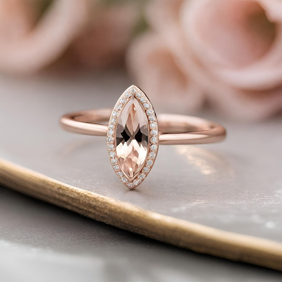 A natural Morganite marquise cut engagement ring with diamond halo in rose gold from Rare Earth Jewelry.