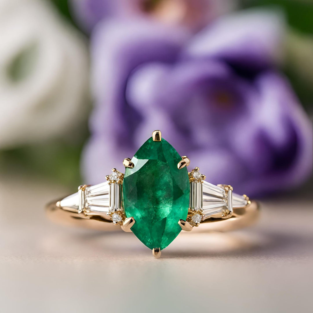 A natural emerald engagement ring with a large marquise cut emerald and tapered diamond baguettes from Rare Earth Jewelry.