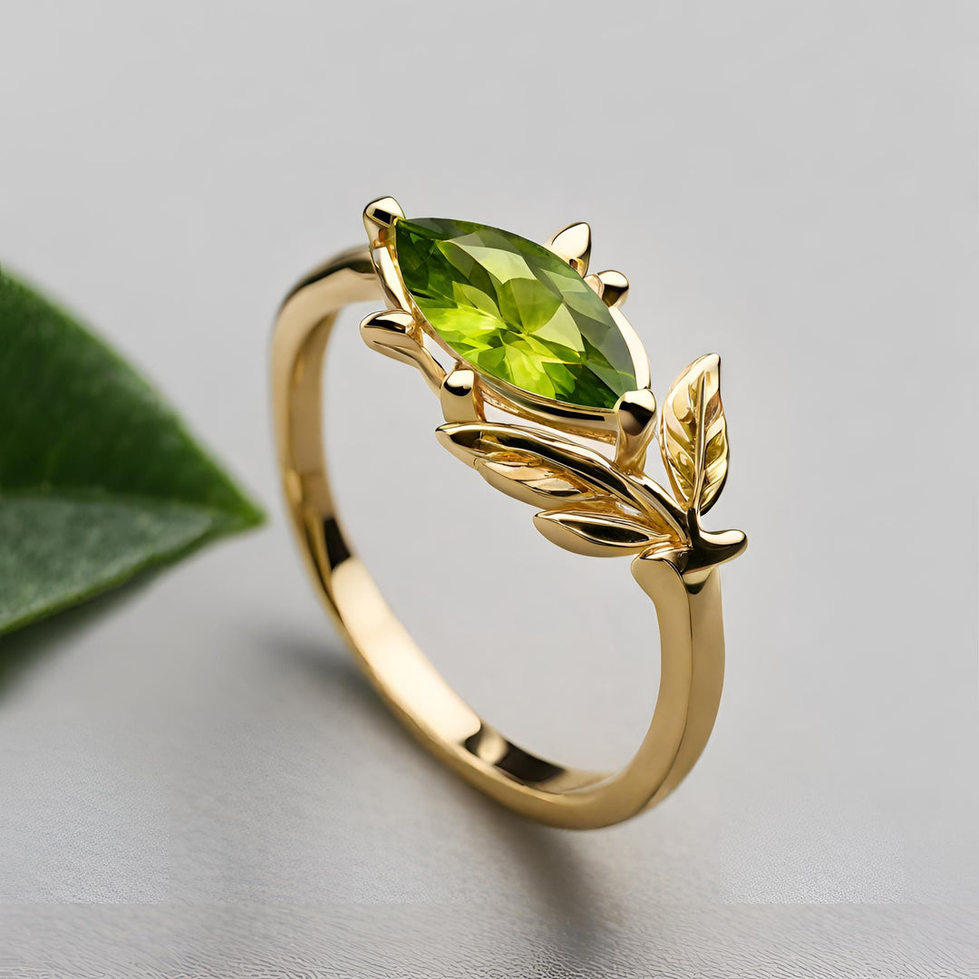 A natural peridot ring in 14K Gold with a marquise cut green Peridot and a contemporary leaf design from Rare Earth Jewelry.