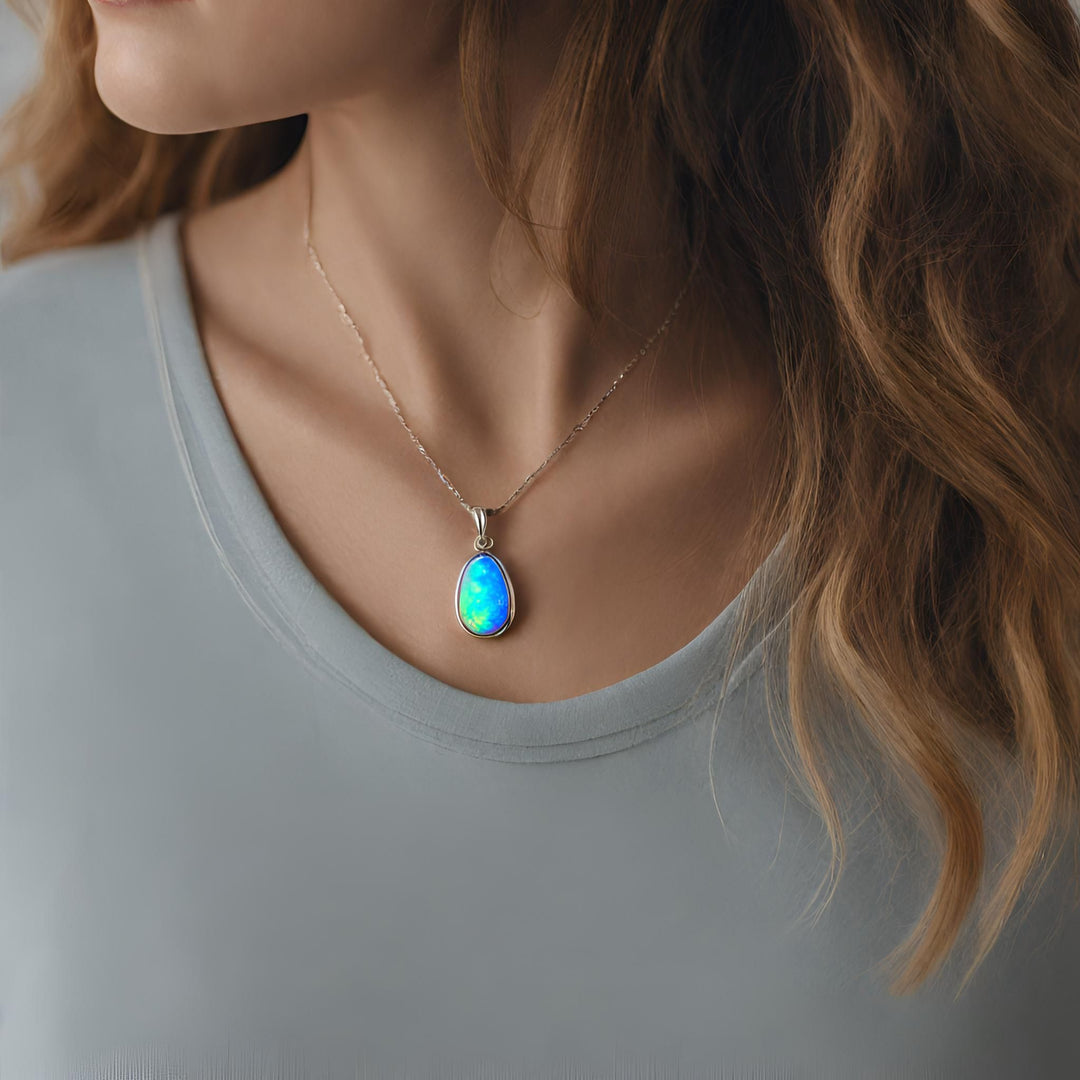 An Opal pendant in a pear cabochon cut opal necklace in 14K Gold from Rare Earth Jewelry.