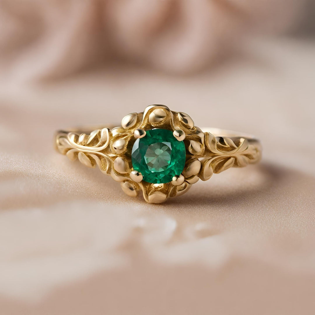 A round natural emerald ring with an ornate baroque design in 18K Yellow Gold from Rare Earth Jewelry.