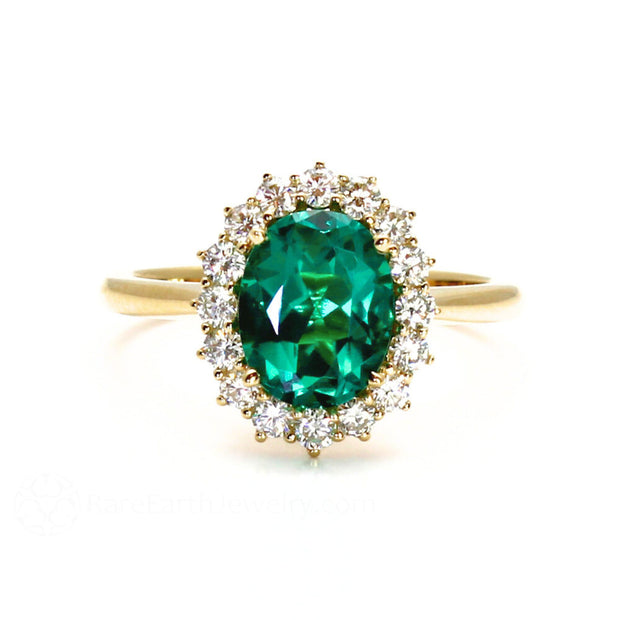 Oval green emerald and diamond ring in a vintage style halo design.  Green stone engagement ring with diamonds.
