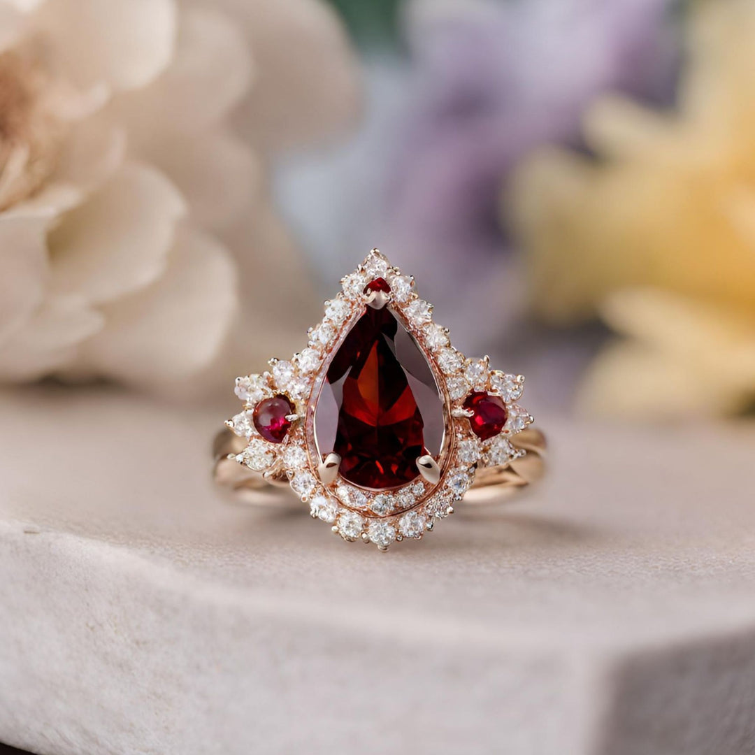 A large pear cut red garnet ring with a dramatic diamond studded double halo from Rare Earth Jewelry.