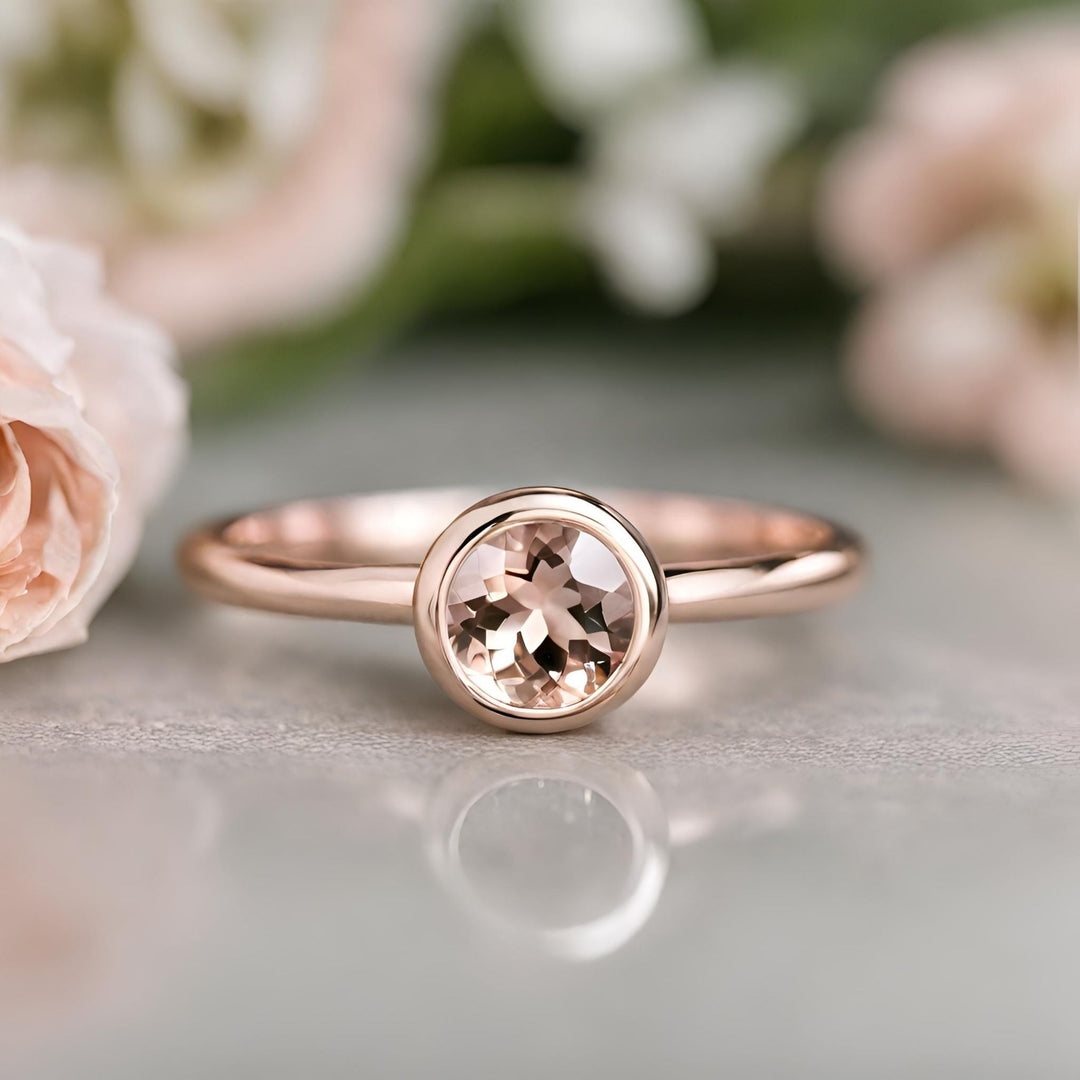 A classic round bezel set morganite ring in rose gold, natural morganite peach gemstone from Rare Earth Jewelry.