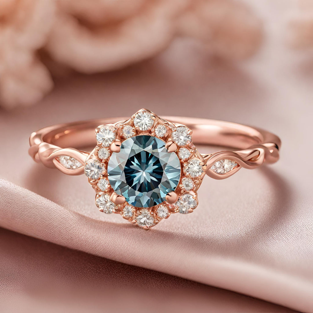 A round teal blue diamond engagement ring in an antique style diamond halo design in rose gold from Rare Earth Jewelry.amonds