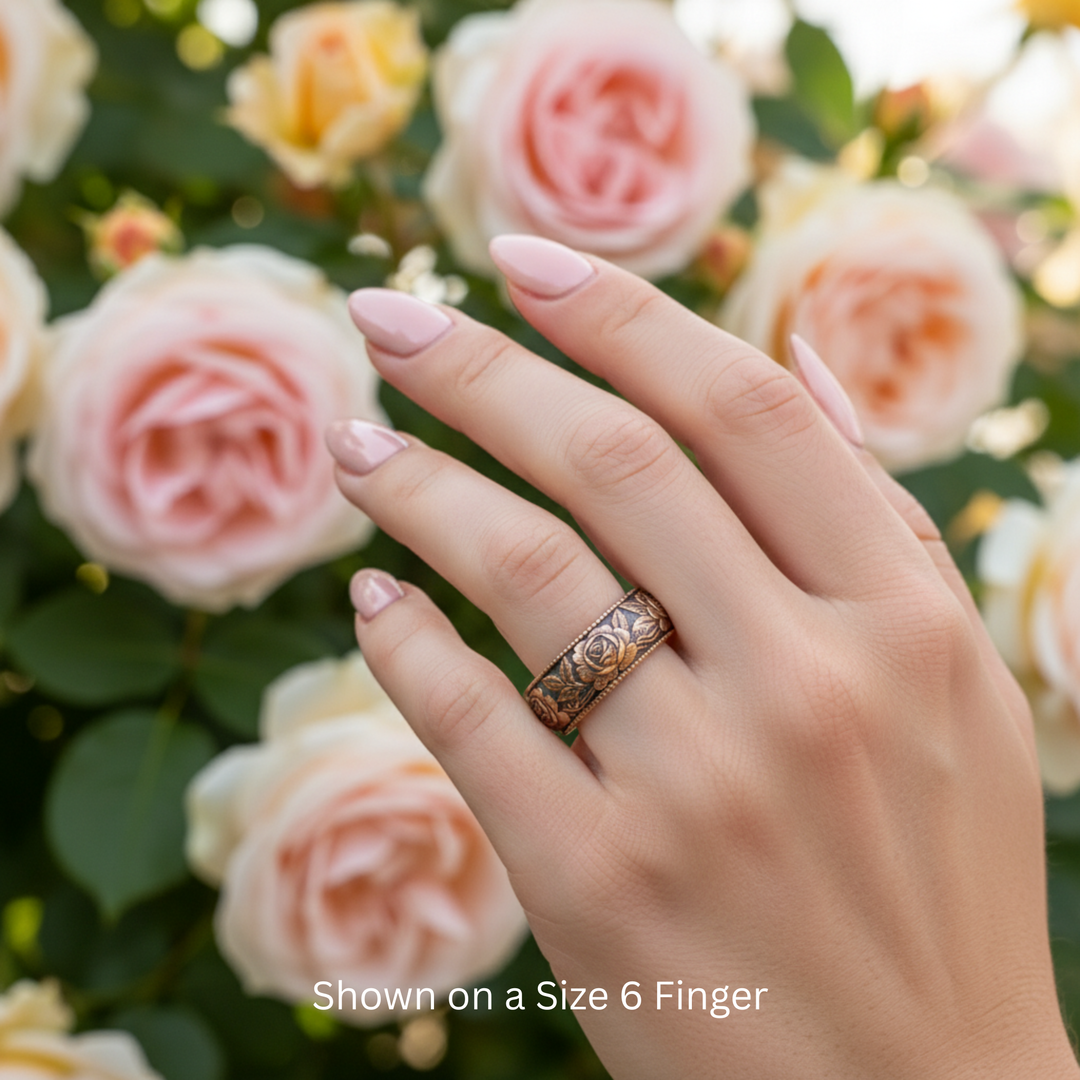 Vintage Rose Wedding Band with Floral Design and Engraved Flowers and Leaves, Shown in 14K Rose Gold with Antique Patina. 8mm Band Displayed on Size 6 Finger. | Rare Earth Jewelry