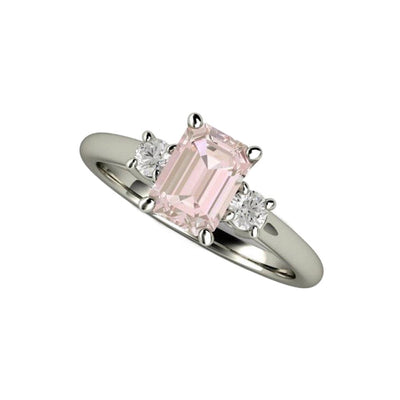 Dainty three-stone engagement ring with emerald-cut pink Morganite and round diamonds on each side. Classic, feminine, and timeless elegance from Rare Earth Jewelry.