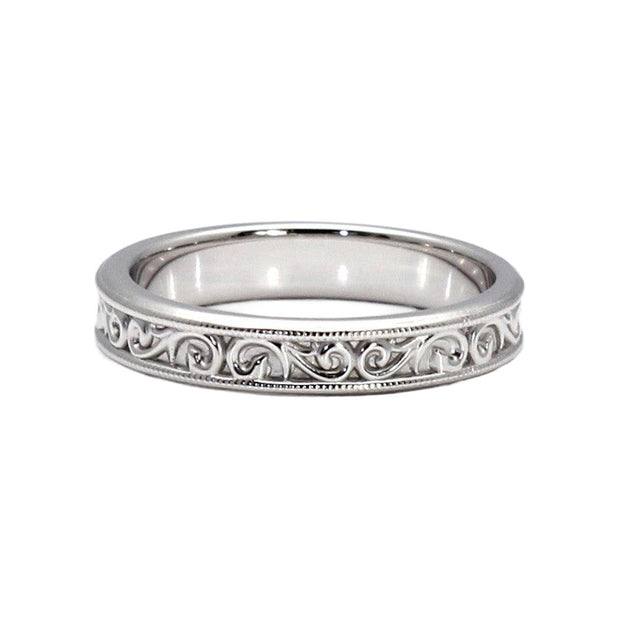 An antique style wedding band measuring 4mm wide with a pretty vintage inspired scroll and filigree design in white gold.