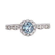 A vintage style Aquamarine ring or engagement ring accented with diamonds.  The ring has a round natural Aquamarine surrounded by  a pretty floral shaped diamond halo and a scalloped band in 14K or 18K or Platinum.