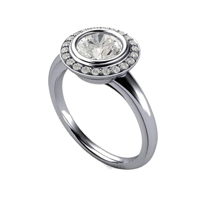 An Art Deco style engagement ring with a 1ct round natural Diamond bezel setting surrounded by a diamond halo in Platinum.