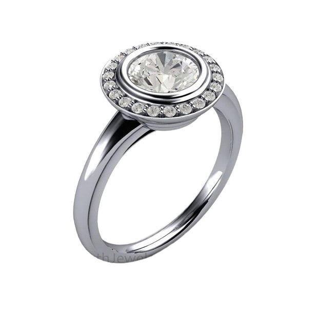 A vintage inspired Moissanite engagement ring with an Art Deco design, a bezel set 1ct round Charles & Colvard Forever One Moissanite and diamond halo from Rare Earth Jewelry.