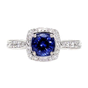 An Art Deco style Blue Sapphire engagement ring with a diamond halo and an engraved scroll design accented with diamonds in 14K, 18K Gold or Platinum from Rare Earth Jewelry.