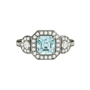 An asscher cut natural Aquamarine engagement ring with a 3 stone diamond halo style in gold or platinum from Rare Earth Jewelry.
