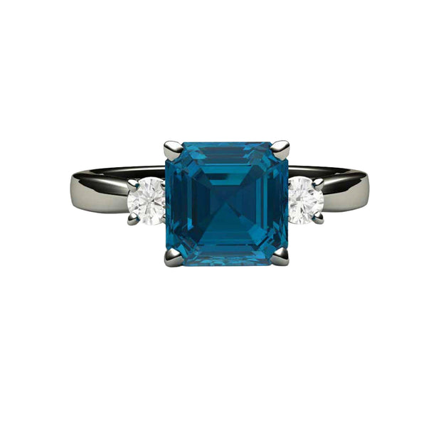 An asscher cut London Blue Topaz ring or engagement ring in a 3 stone style with diamond accents in gold or platinum from Rare Earth Jewelry.
