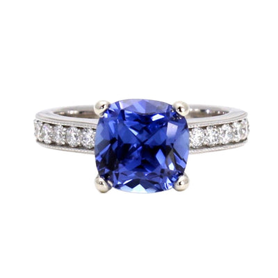 A large 3ct square cushion cut Blue Sapphire engagement ring in a cathedral solitaire setting with diamond accents and a milgrain beaded edge in gold or platinum.