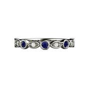 A Blue Sapphire and Diamond wedding ring, anniversary band or stacking ring.  The band has round bezel set blue sapphires and diamonds in gold or platinum.