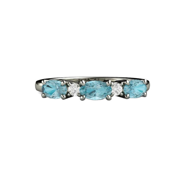 A oval blue zircon and diamond ring in gold or platinum.  The natural Blue Zircons are set east to west with natural diamonds in between.  A unique wedding ring or anniversary band with blue gemstones.