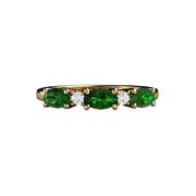 A unique Chrome Green Tourmaline ring with diamonds.  Oval cut natural green tourmalines are set east to west in this unique band, shown in yellow gold.