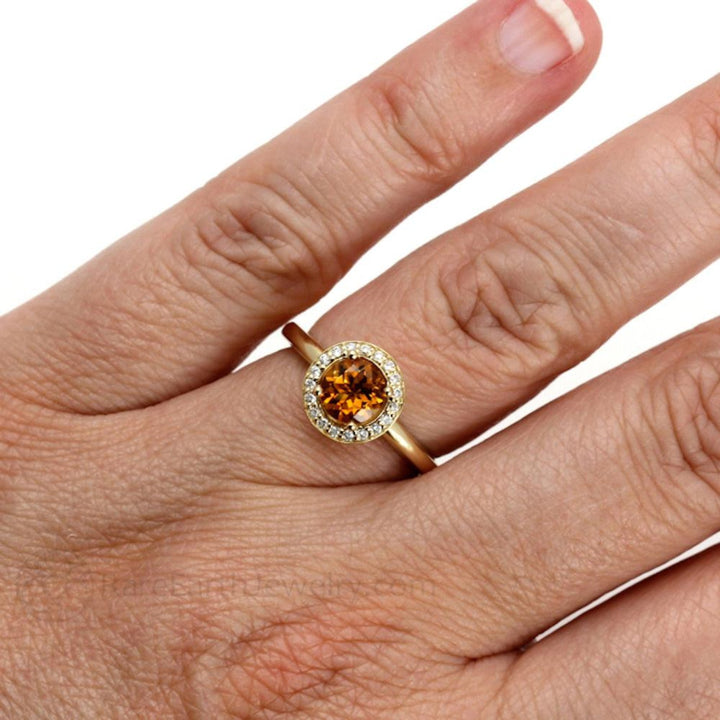 Citrine Diamond Halo Ring on hand, round-cut citrine with diamond halo in 14K gold.