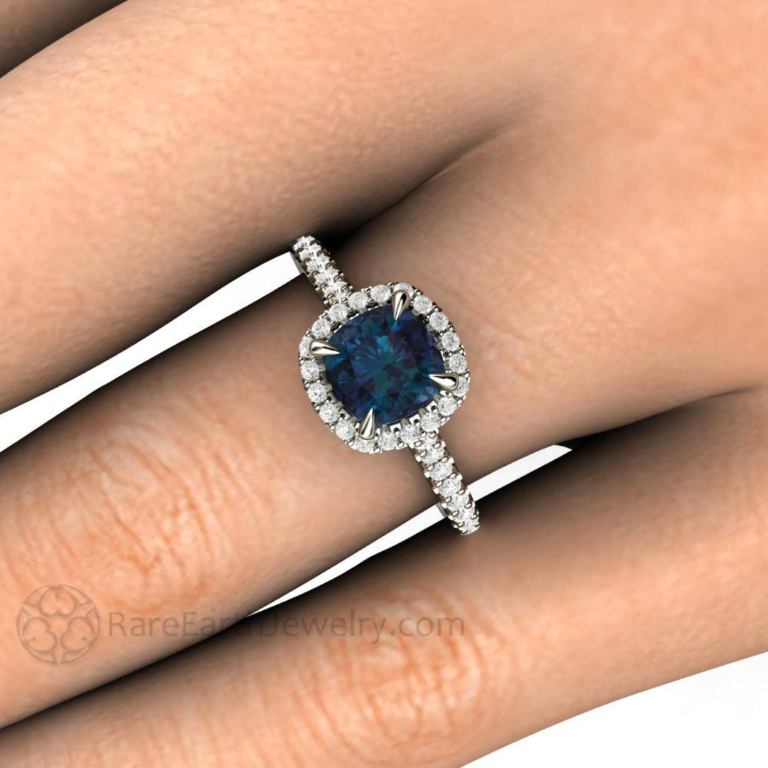 Close Up of Alexandrite Engagement Ring | Cushion Cut Color Changing Stone with Diamond Halo on the Finger