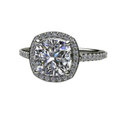 A halo style Moissanite engagement ring with a square cushion cut Charles & Colvard Forever One Moissanite and a pave set halo and dainty, thin diamond accented band in gold or platinum.  Moissanite is a lab grown diamond alternative.