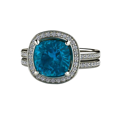 A cushion cut London Blue Topaz engagement ring and matching diamond wedding band in a diamond halo style in gold or platinum.  December birthstone jewelry.