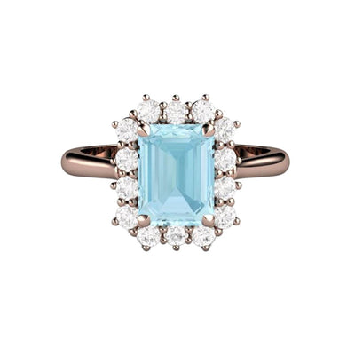 A vintage style Aquamarine and diamond engagement ring with a diamond halo cluster design. Natural Aquamarine ring in gold or platinum, shown here in rose gold.  Unique engagement ring from Rare Earth Jewelry.