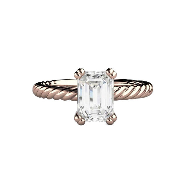 An emerald cut Moissanite solitaire engagement ring with a rope twisted band in gold or platinum, shown in rose gold, available exclusively from Rare Earth Jewelry.