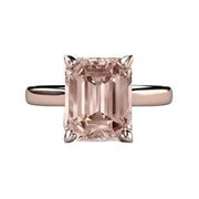 A natural Morganite enagement ring in a classic solitaire design with a large peach pink emerald cut Morganite and heart shaped prongs, shown in rose gold and available exclusively from Rare Earth Jewelry..