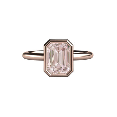 An emerald cut natural morganite ring in a bezel set solitaire engagement ring in rose gold.