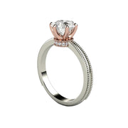 A Forever One Moissanite engagement ring with a unique diamond studded crown design, 6 prong solitaire with milgrain beaded edge in two-tone rose gold and white gold from Rare Earth Jewelry.