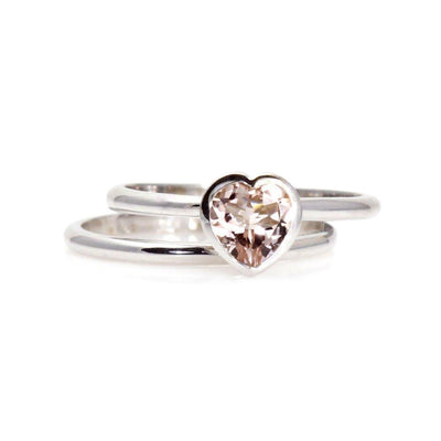 A heart shaped Morganite ring with a heart cut natural Morganite in a bezel setting, a unique solitaire engagement ring and matching wedding band in gold or platinum.
