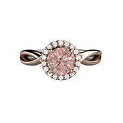 A light pink Sapphire engagement ring with a beautiful pastel champagne pink Sapphire center surrounded by a diamond halo and an infinity design band. Available in gold or platinum from Rare Earth Jewelry.