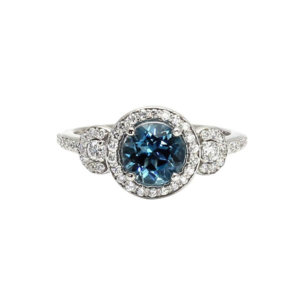 A natural London Blue Topaz engagement ring with a 3 stone design and diamond halos in gold or platinum from Rare Earth Jewelry.