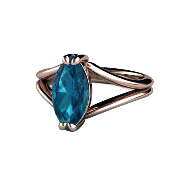 A marquise cut natural London Blue Topaz ring with a modern, split shank double band solitaire design.  December birthstone ring available in gold or platinum, shown in rose gold from Rare Earth Jewelry.