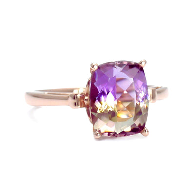 A natural Ametrine ring with a large cushion cut Ametrine, a unique bi-colored purple and yellow gemstone in a solitaire setting with a fleur de lis design from Rare Earth Jewelry.