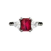 An emerald cut natural Ruby engagement ring with diamond trillions in a classic three stone setting available in gold or platinum from Rare Earth Jewelry.