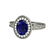 A vintage inspired oval Blue Sapphire engagement ring with an Art Deco style and diamond halo, with scrollwork and milgrain beaded details in 14K, 18K or Platinum.