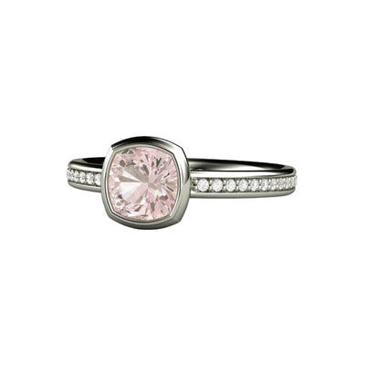 A cushion cut light pink sapphire engagement ring in a simple bezel setting with diamond accents in the band in gold or platinum.