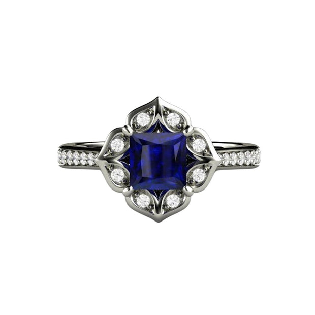 A unique princess cut Blue Sapphire and diamond engagement ring. A square Blue Sapphire is offset with a diamond halo and accented shank in a vintage style design.