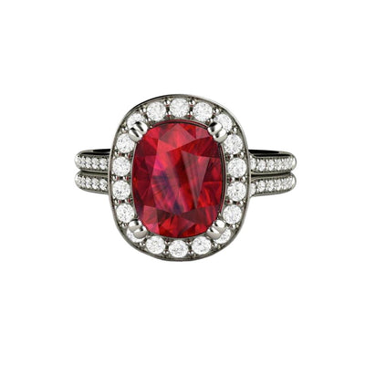 A large cushion cut Ruby engagement ring with a split shank diamond halo design with matching diamond wedding band in gold or platinum.