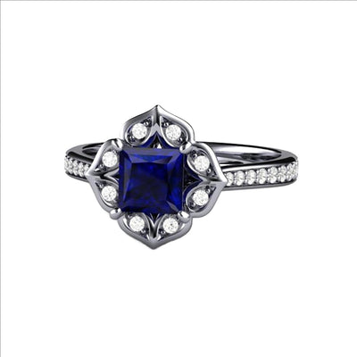 A unique princess cut Blue Sapphire and diamond engagement ring. A square Blue Sapphire is offset with a diamond halo and accented shank in a vintage style design from Rare Earth Jewelry.