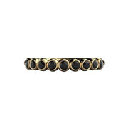 A natural black diamond band in yellow gold. A bubble style round bezel set wedding ring or stacking ring from Rare Earth Jewelry.