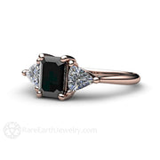 An emerald cut natural black diamond engagement ring in a three stone style with diamond trillions from Rare Earth Jewelry