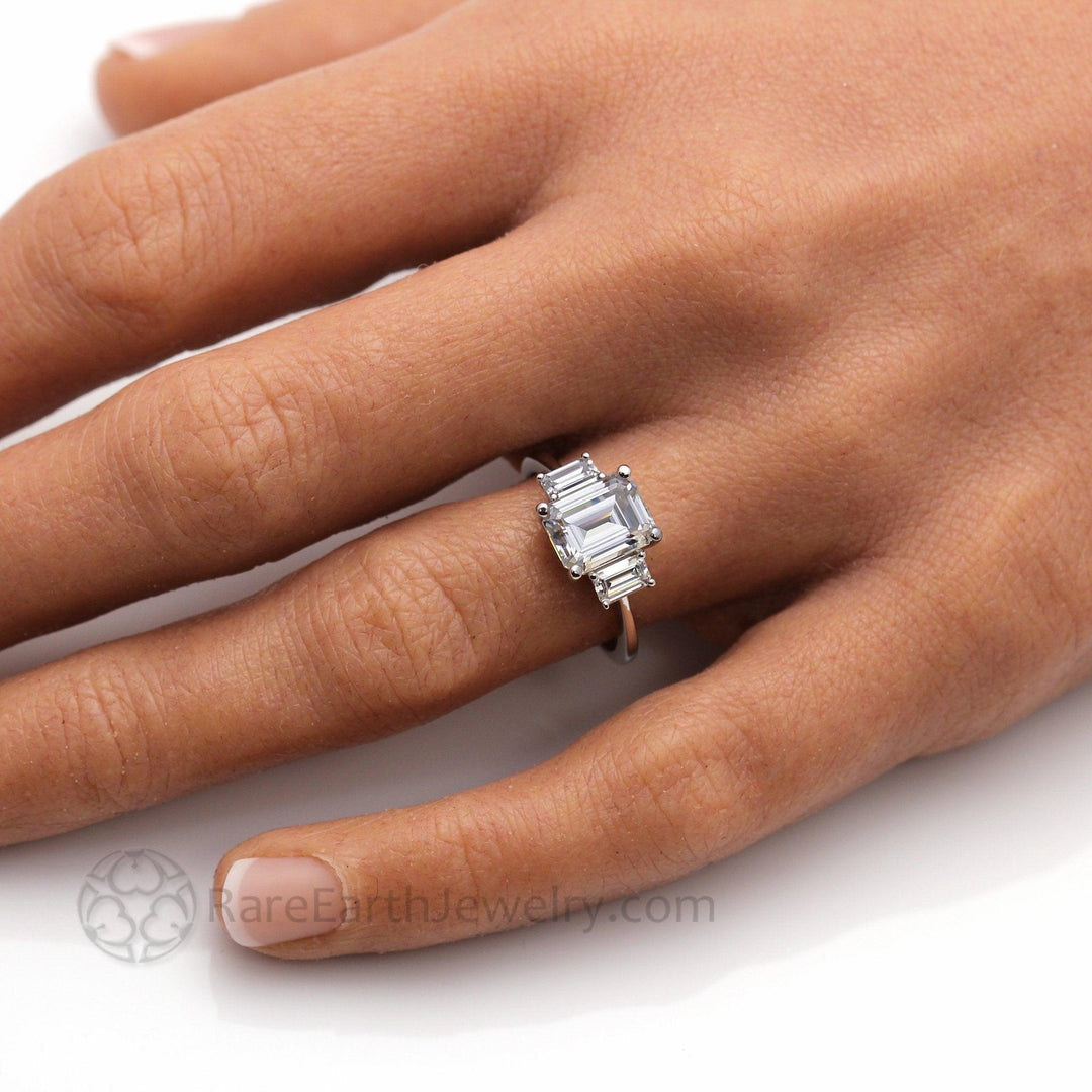 9x7mm Emerald Cut Moissanite Ring on the Finger, 3 Stone Style Colorless Moissanite Engagement Ring | Rare Earth Jewelry