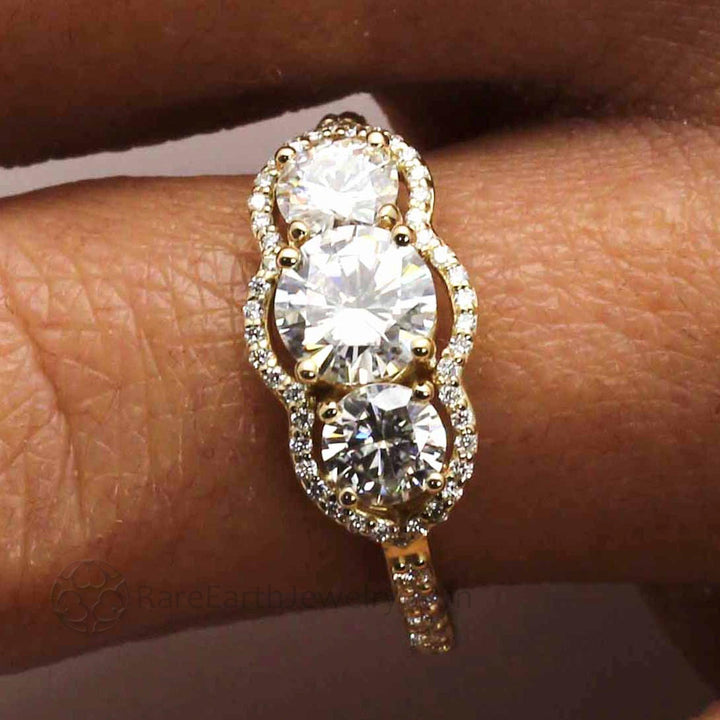Close up of Vintage Inspired Moissanite Engagement Ring  on the Finger, Three Stone Diamond Halo | Rare Earth Jewelry